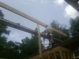 Carpenter setting a ridge beam over a new addition frame — Ice Dam Removal by Roofing Brothers in Etowah