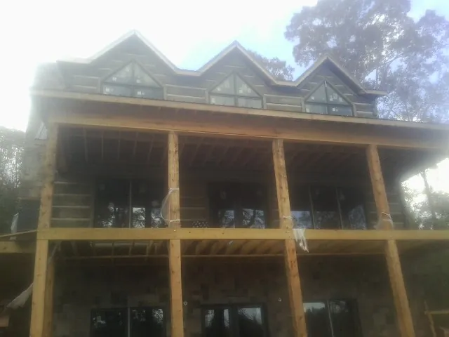 Dormers and porch framing on a large log home under construction — Roof Coating work by our crew in Etowah