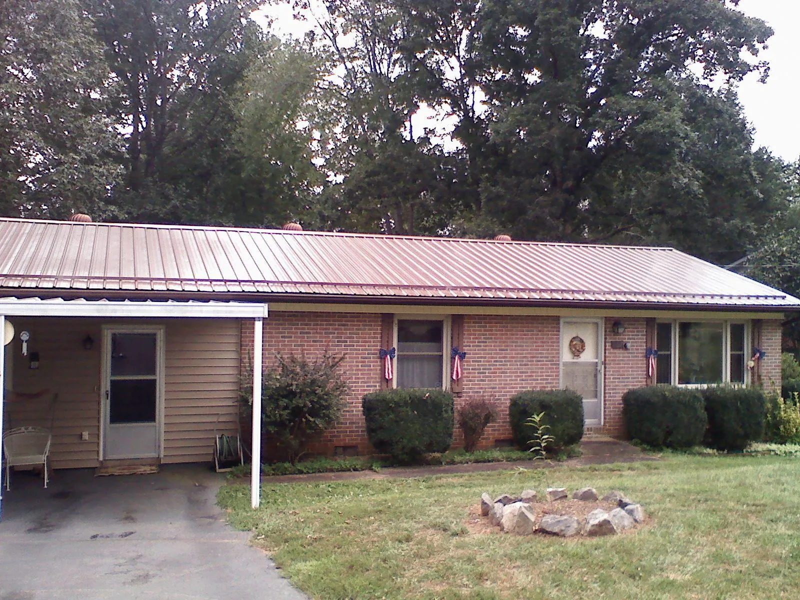 Bronze metal roof and carport on a brick ranch home — Roof Repair work by our crew in Etowah