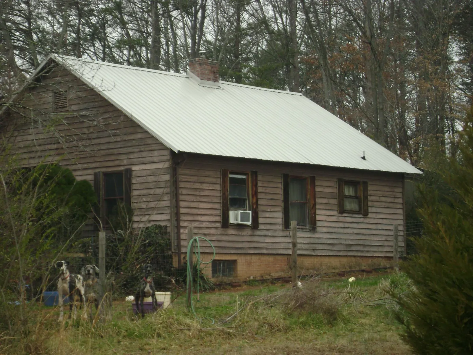 White metal roof on an old wood sided farmhouse, from a Metal Roof Installation job in Etowah